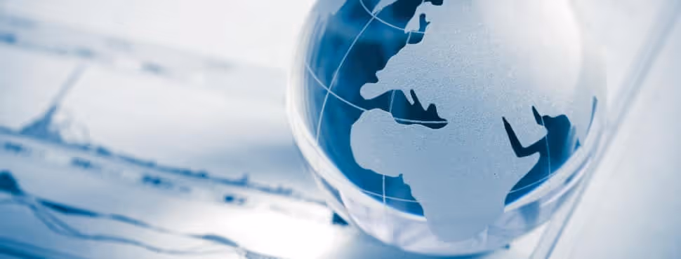 Glass globe with world map showing Africa and Europe on a blurred background.