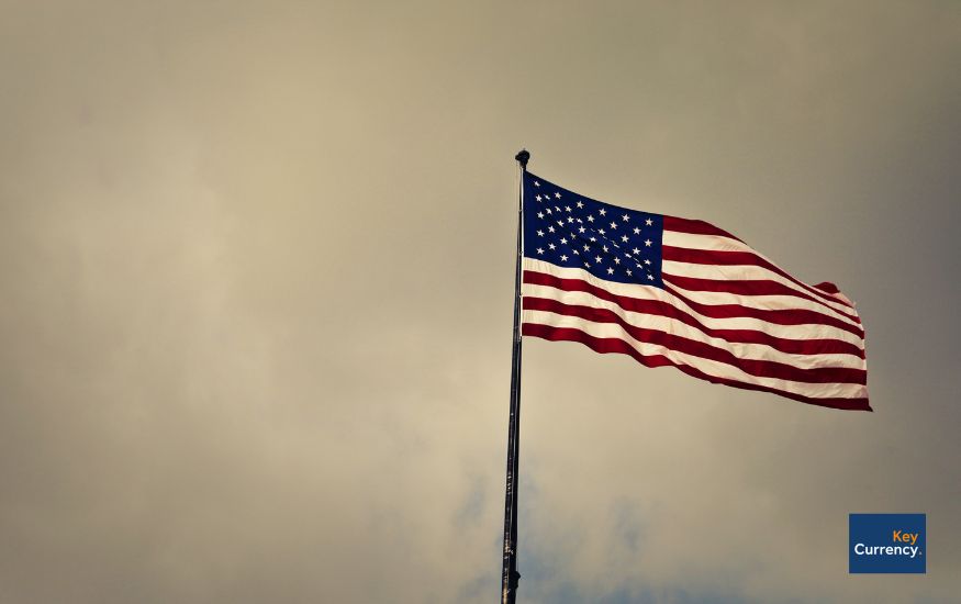 American flag on a flag pole on a windy and cloudy day. 